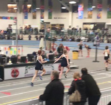 Junior Tess Contois passes the baton  off to sophomore Gaylan Ryuss in the 4x200 meter relay.
