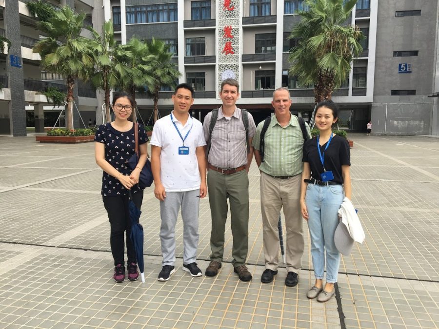 Mr. Hickey and Mr. Campbell with some teachers in front of one of the traditional Mingde schools in Shenzhen, China.