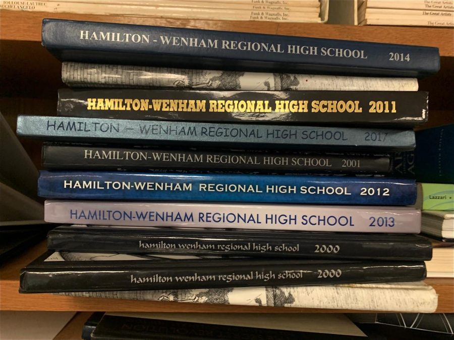 Students+work+to+add+the+2021-2022+yearbook+to+the+pile.