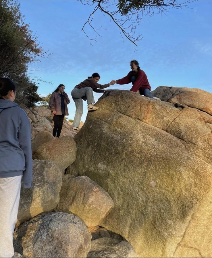 Outing Club students climb on the rocks at Singing Beach on October 16.