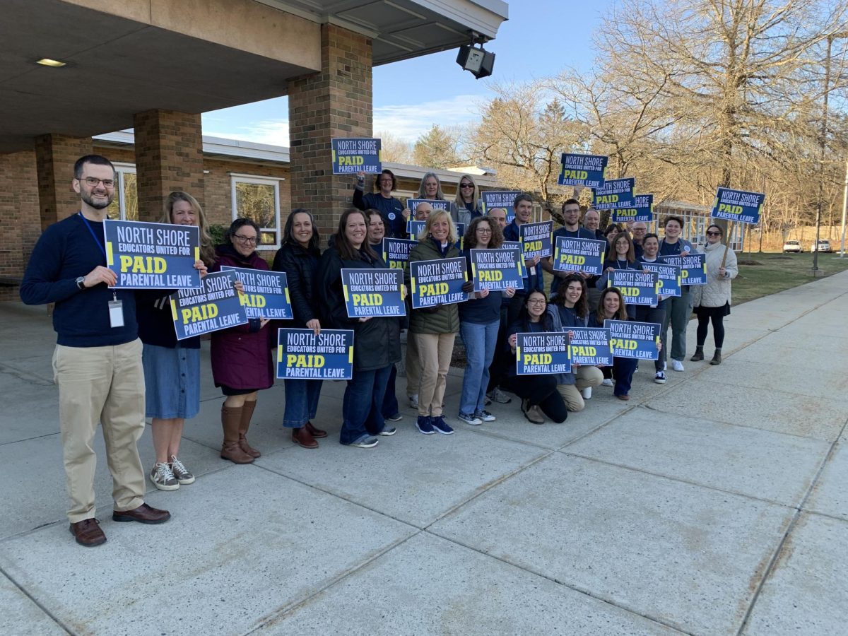 Teachers at Hamiton Wenham Regional High School stand outside the school to voice their support for paid parental leave. 